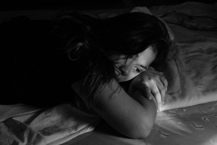 Black and white close up image of a girl laying on a pillow 