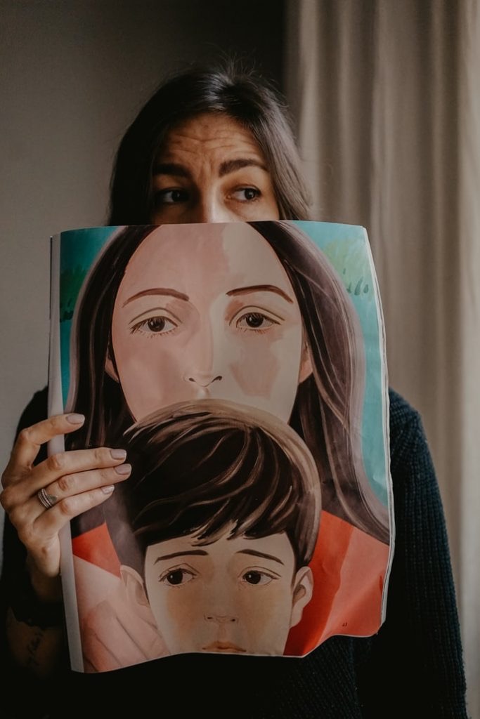 Imposter syndrome woman holding a portrait of herself and a small child over her face 