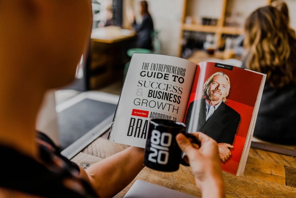 Keys to a successful business a person holding a book with the title the entrepreneurs guide to success and growth in business