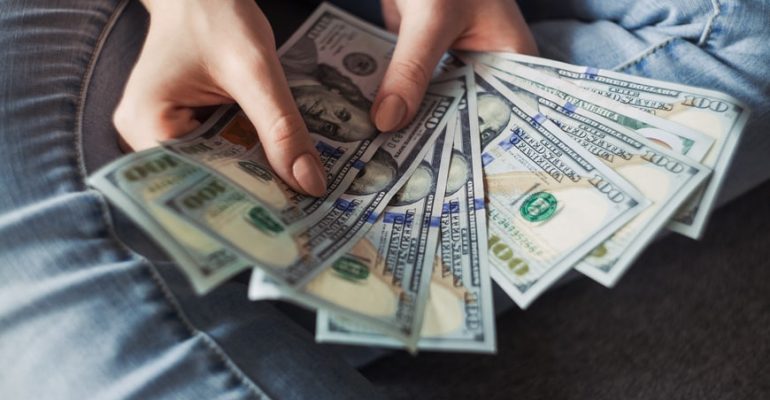 Tips for salary negotiation person holding multiple hundred dollar bills