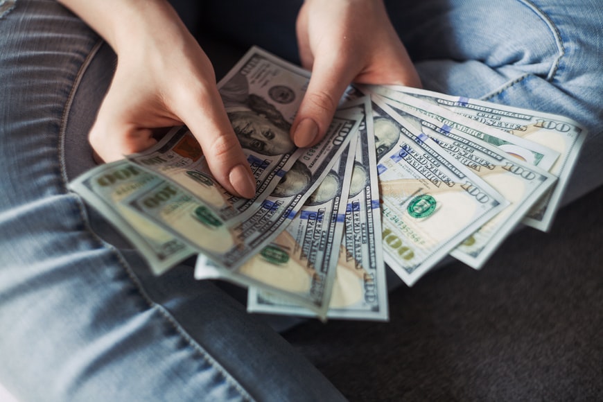 Tips for salary negotiation person holding multiple hundred dollar bills 