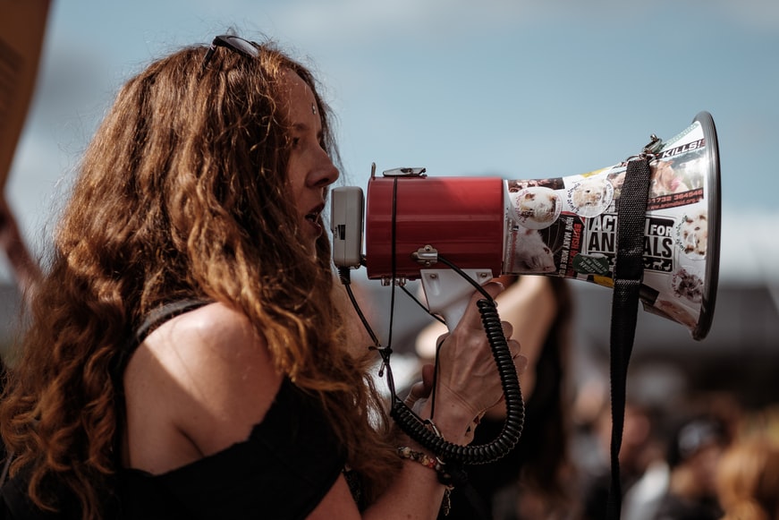 Self care advocate woman speaking into megaphone 