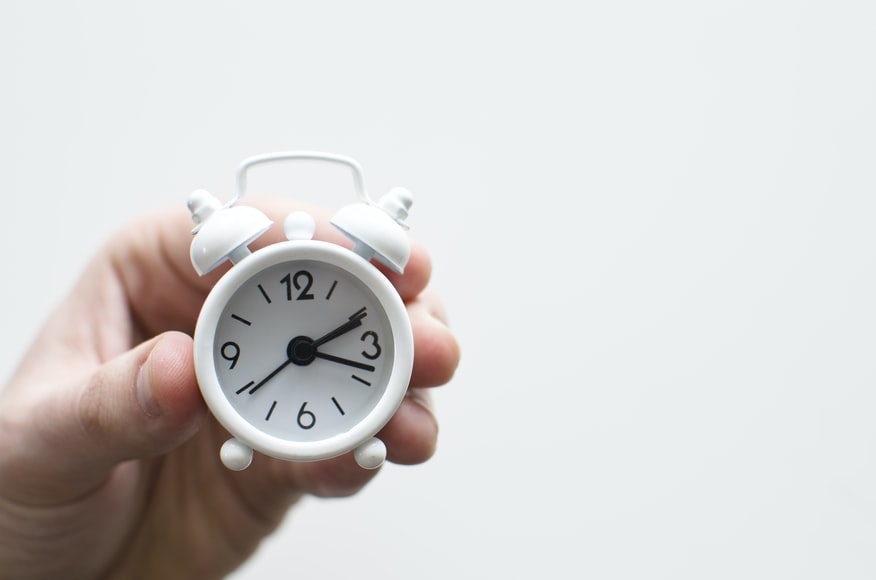 Close up of a hand holding a clock 