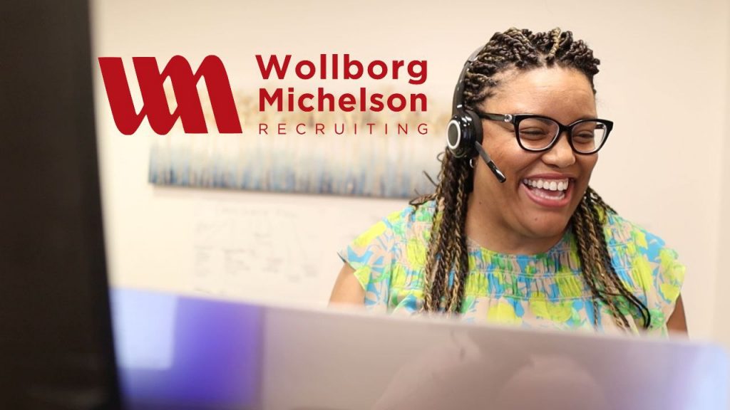 Wollborg Michelson recruiting, black woman smiling while at computer desk 