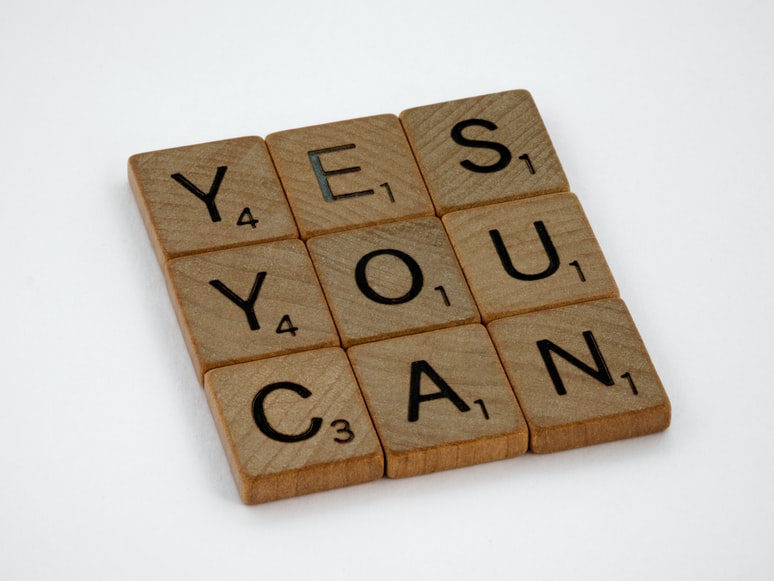 Wooden scrabble blocks spelling out the words yes you can 