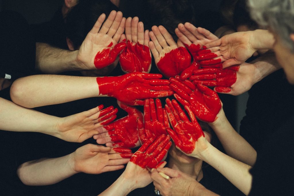 Hands painted red to make a heart 