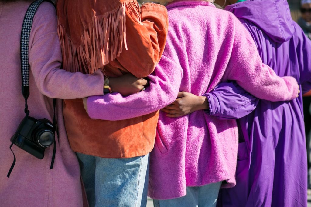 Women hugging wearing purple 