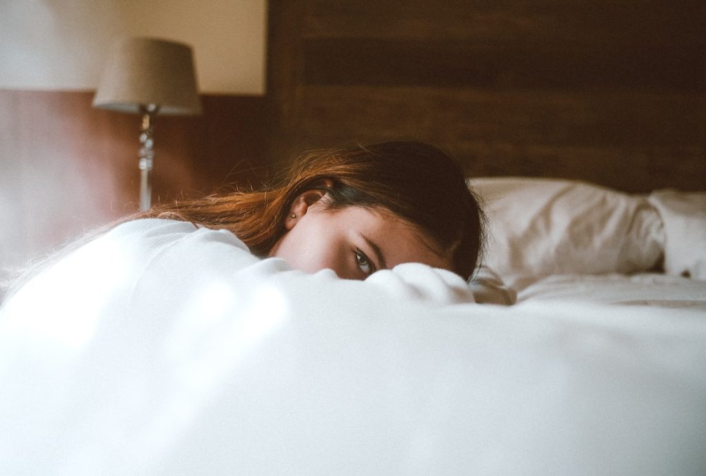 Girl laying on bed awake 