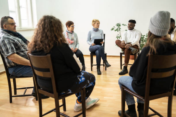 Group therapy support meeting talking about their mental health in a modern mental health facility